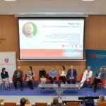 Uczestnicy forum na podwyższeniu podczas prezentacji