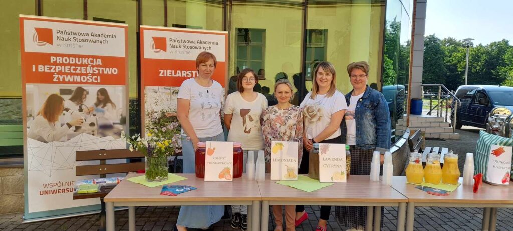 pracownicy i studenci przy stoisku z napojami