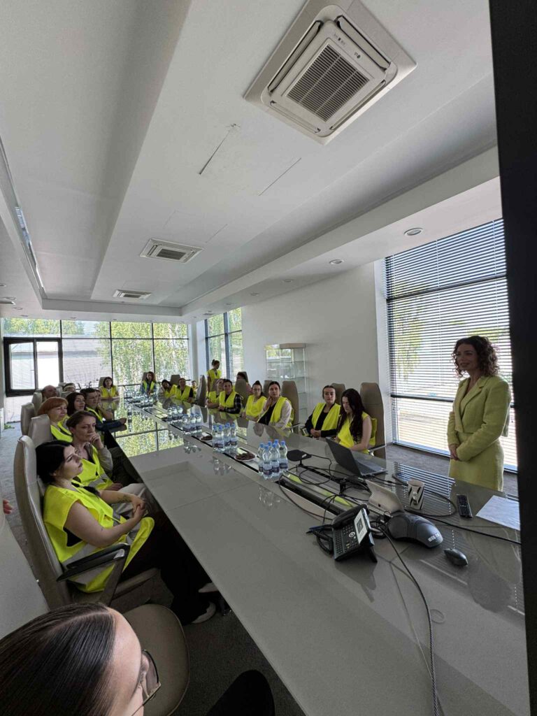 sala konferencyjna wzdłuż stołu siedzą studenci z boku pani Dyrektor stoi i opowiada