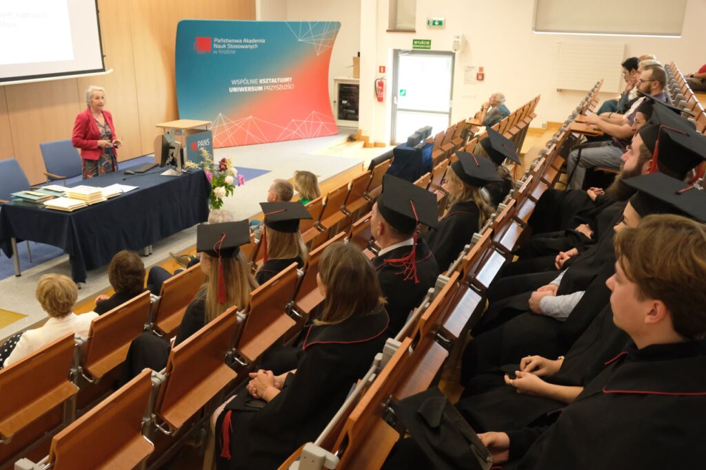 wykład, sala studenci w togach siedzą