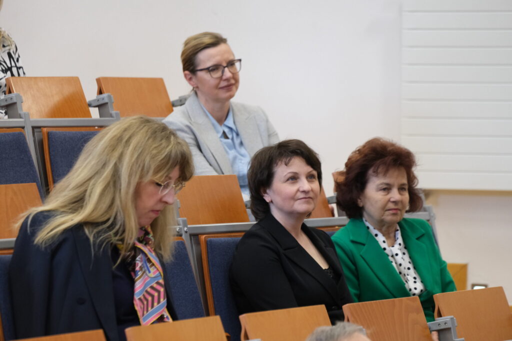 uczestnicy konferencji siedzą na sali wykładowej