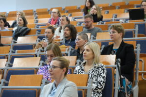 uczestnicy konferencji siedzą na sali wykładowej