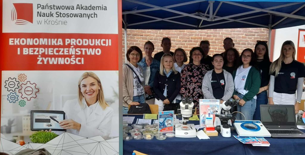 Stoisko kierunku wraz z pracownikami i studentami, baner kierunku