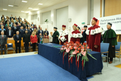 aula i władze uczelni stoją podczas hymnu