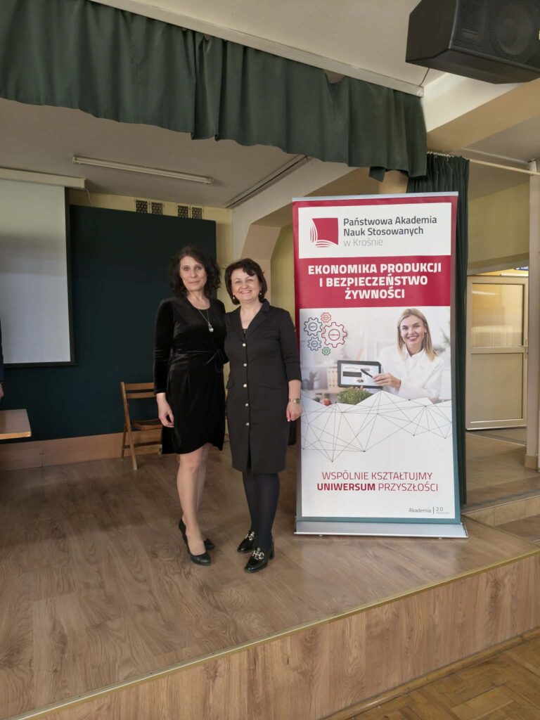 Na scenie stoi profesor Marczak z nauczycielem, z boku baner kierunku Ekonomika produkcji i bezpieczeństwo żywności,