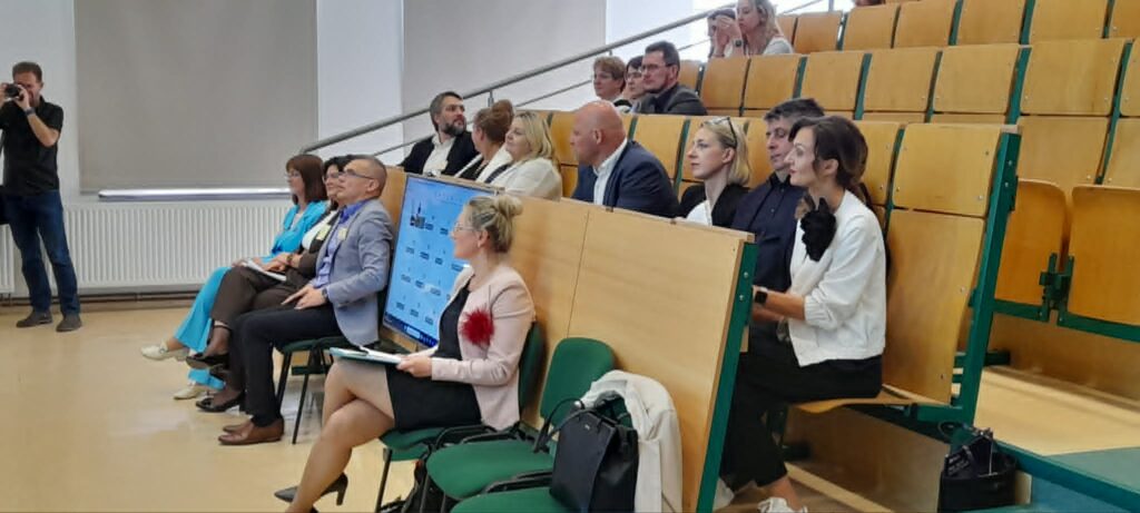 Kierownicy zakładów i nauczyciele siedzą na auli